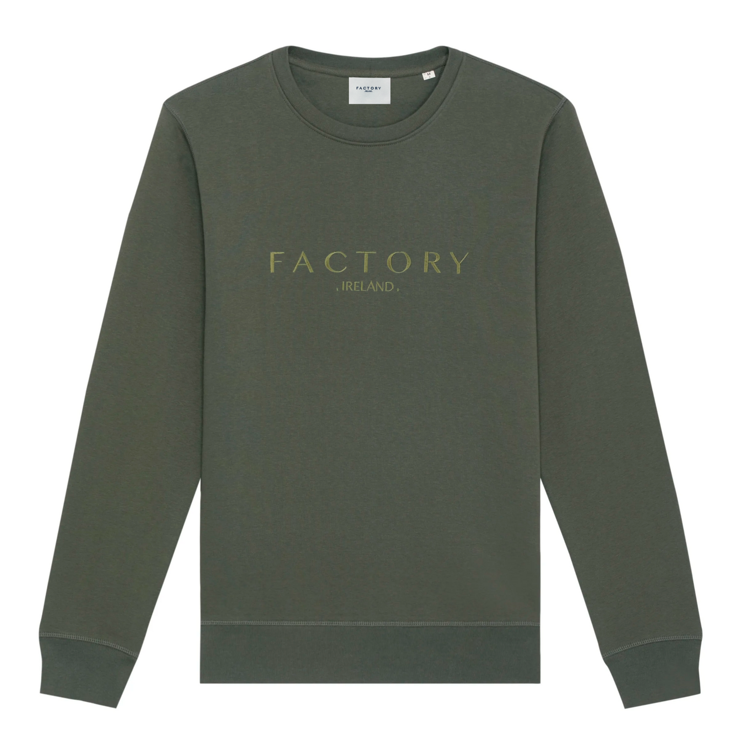 A green sweatshirt with 'Factory Ireland' embroidered on the front, set-in sleeves, and a flatlock topstitch on the seams.