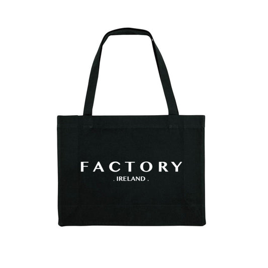 Black tote bag with 'FACTORY IRELAND' text on a white background